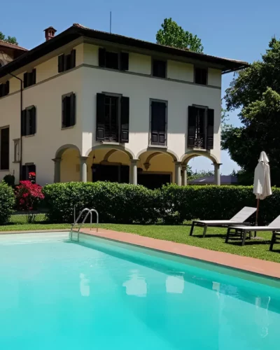 A large swimming pool in front of an Italian villa