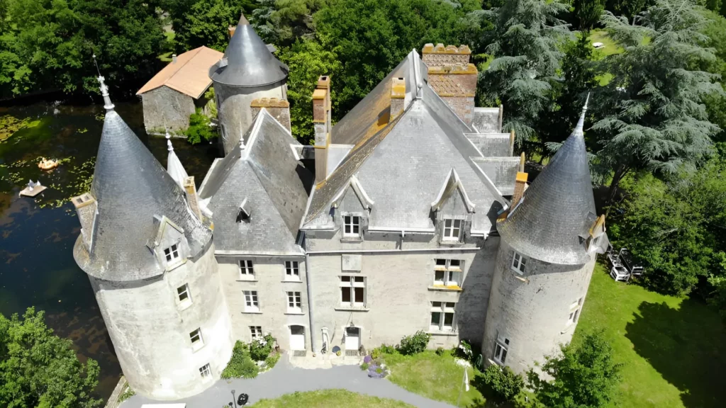 An aerial shot of a castle-like building surrounded by trees