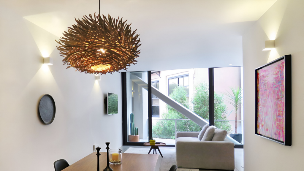 A smart dining room of a loft with a sizable pendant light suspended from the ceiling
