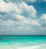 A person paragliding on the beach in Cancun