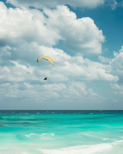 A person paragliding on the beach in Cancun