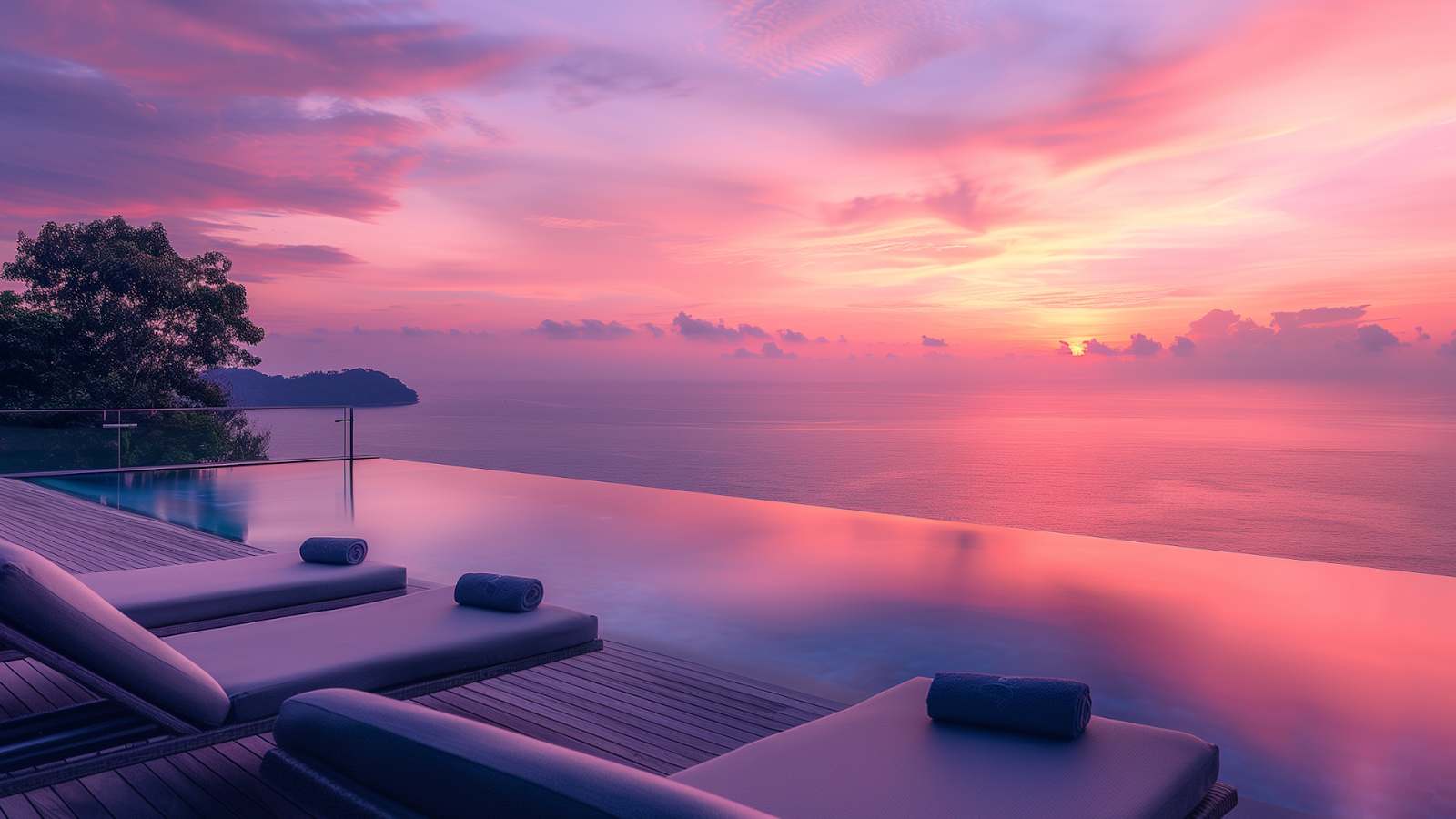 Early morning view of a luxury villa pool in Phuket, with the pool reflecting the colorful sunrise over the Andaman Sea.