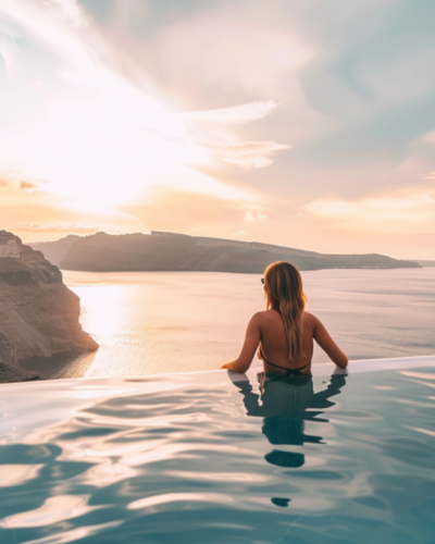 A woman swimming in an infinity pool in Santorini