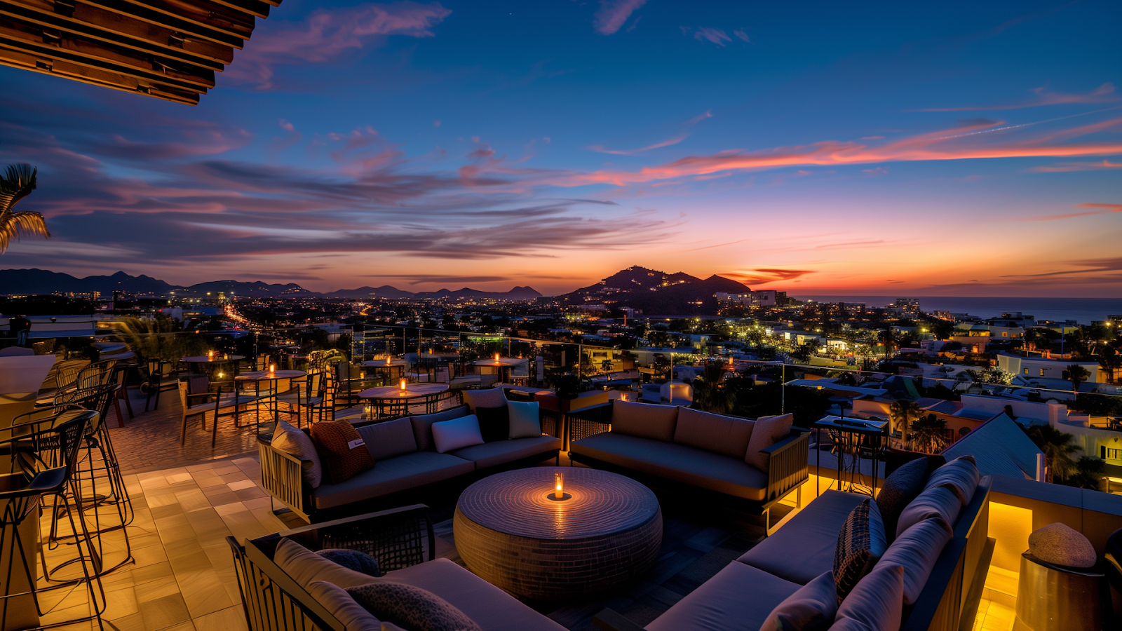 A rooftop bar in Cabo San Lucas, with stunning city views and a beautiful sunset in the background.