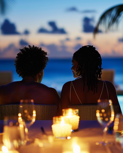 A couple enjoys a serene candlelit dinner by a pool under the stars in the Bahamas.